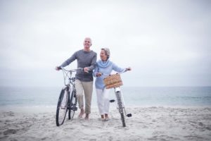 Couple de personnes âgées à vélo sur la plage